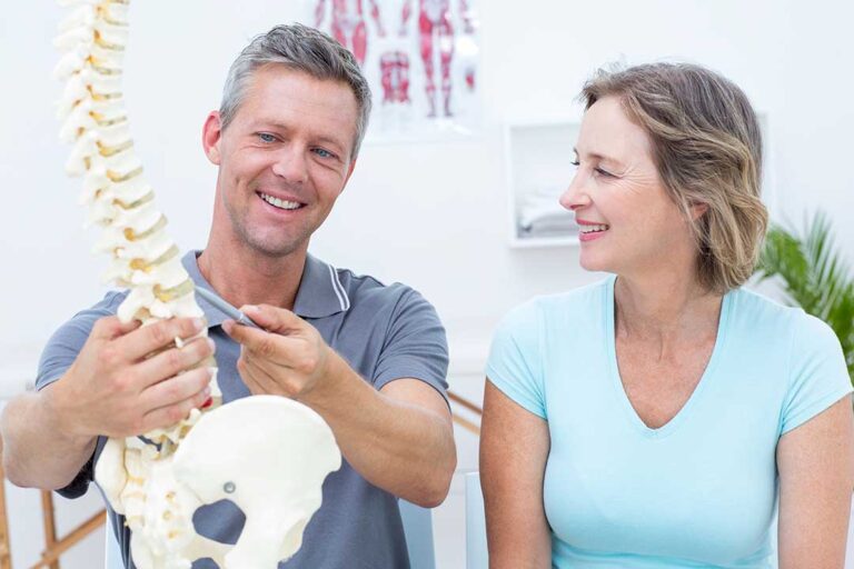 Clinician uses a smooth metal instrument on a patient’s calf during a soft-tissue treatment session.